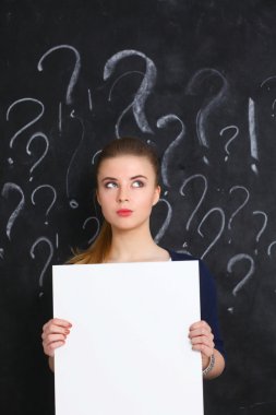 Boş gri bir arka plan üzerinde soru işareti ile genç kız