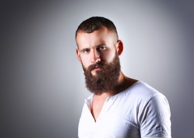 Ayakta, gri arka plan üzerinde izole yakışıklı adam portresi