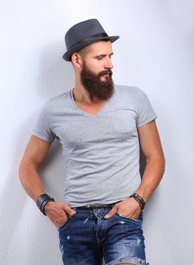 Ayakta, gri arka plan üzerinde izole yakışıklı adam portresi