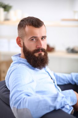 Genç işadamı koltukta oturuyor.