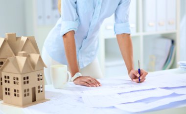 Ofisinde planları olan kadın mimarın portresi.