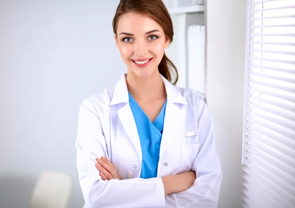 Προσωπογραφία νεαρής γυναίκας γιατρού με λευκό παλτό που στέκεται στο νοσοκομείο — Φωτογραφία Αρχείου