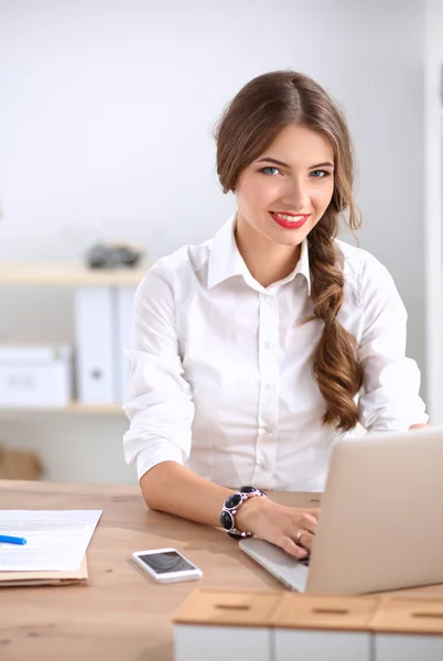 Attraktive Geschäftsfrau sitzt auf Schreibtisch im Büro — Stockfoto