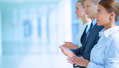 Gülümseyen iş adamları ofiste iyi bir sunumu alkışlıyorlar.