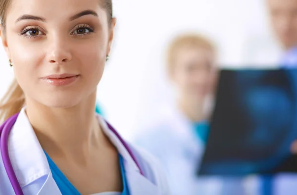 Attractive female doctor in front of medical group — Stock Photo, Image