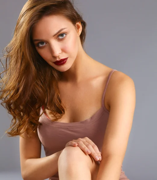 Beautiful barefoot woman sitting on the floor — Stock Photo, Image