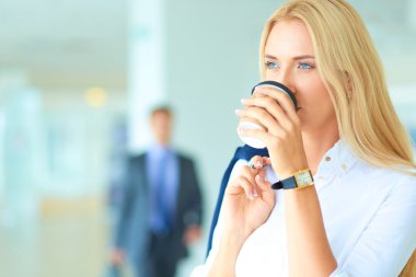 Yound kadın ayakta ofisindeki kahve içmek