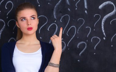 soru işareti gri bir arka plan üzerinde bulunan genç kız