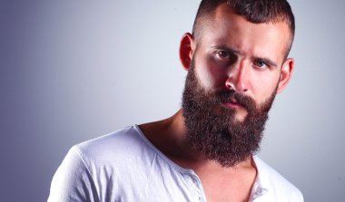 ayakta, gri arka plan üzerinde izole yakışıklı sakallı adam portresi