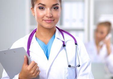 Hastanede üniformalı, gülümseyen bir kadın doktor.