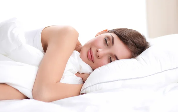 Красивая девушка спит в спальне, лежа на кровати — стоковое фото
