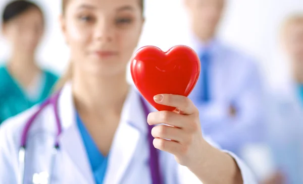 Female doctor with stethoscope holding heart — Stock Photo, Image