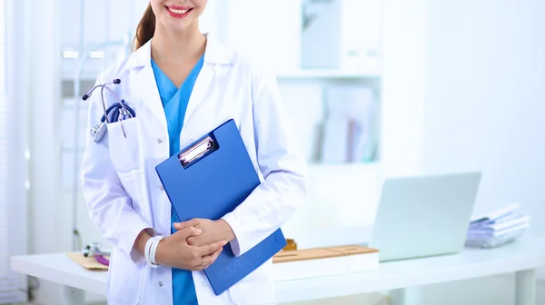 Retrato de una joven doctora con una bata blanca de pie en el hospital — Foto de Stock