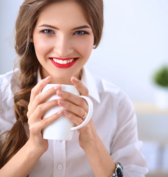 Aantrekkelijke zakenvrouw zit op het bureau in het kantoor — Stockfoto