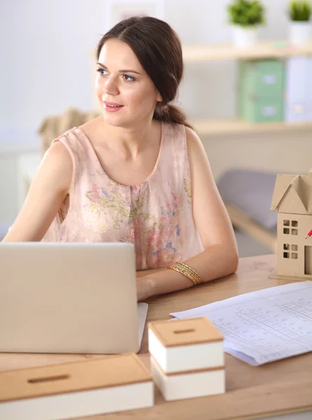 Aantrekkelijke zakenvrouw zit op het bureau in het kantoor — Stockfoto