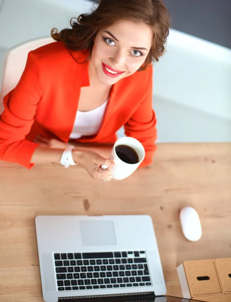 Attraktive Frau sitzt im Büro am Schreibtisch und arbeitet mit Laptop — Stockfoto