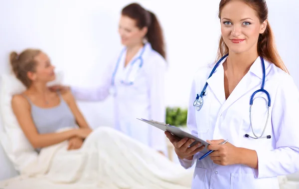 Smiling female doctor with a folder in uniform standing at hospital — Stock Photo, Image
