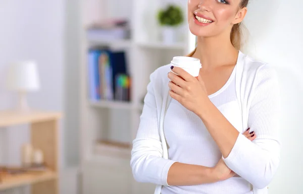 Attractive young businesswoman standing  near wall in office — Stock Photo, Image