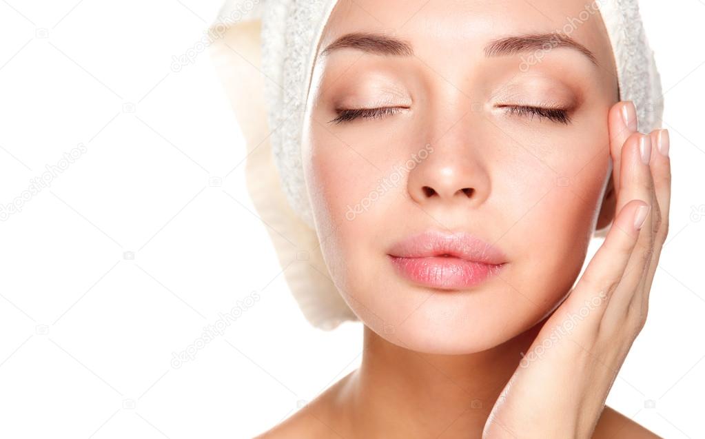 Portrait of beautiful girl touching her face with a towel on  head