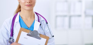 Kadın doktor hastanede dosyayla bekliyor.