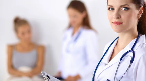 Smiling perempuan dokter dengan folder berseragam berdiri di rumah sakit — Stok Foto