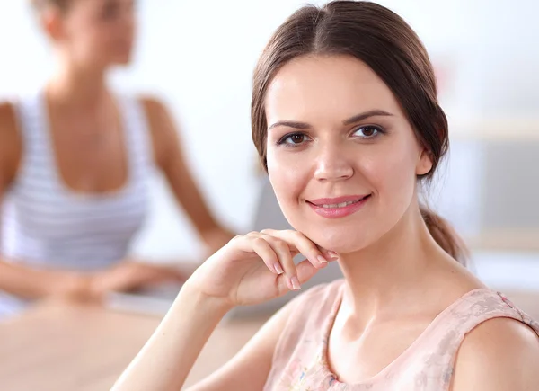 Aantrekkelijke zakenvrouw zit op het bureau in het kantoor — Stockfoto