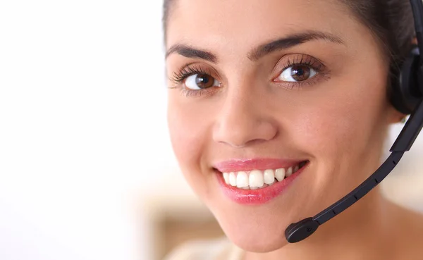 Retrato de una hermosa mujer de negocios trabajando en su escritorio con auriculares y portátil — Foto de Stock