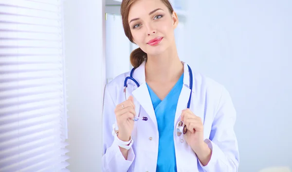 Femme médecin est debout près de la fenêtre avec les bras croisés, isolé — Photo