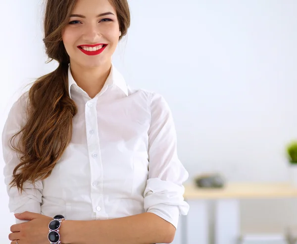 Atraktivní podnikatelka stojící u zdi v kanceláři — Stock fotografie