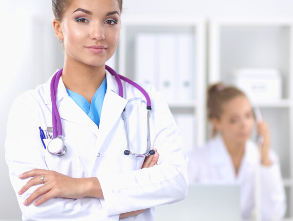 Portrait of young woman doctor with white coat standing in hospital