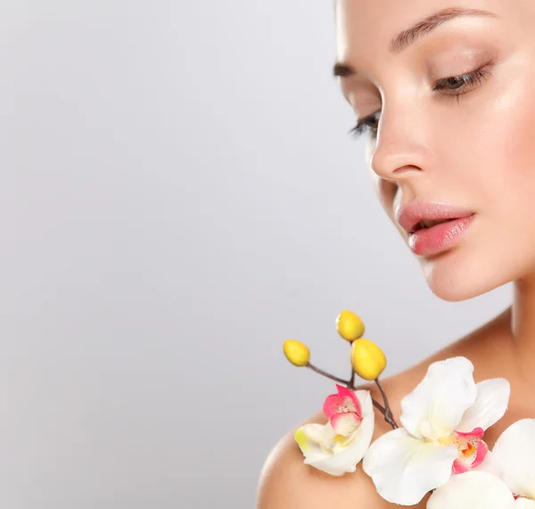 Woman in towel with orchid flowers — Stock Photo, Image