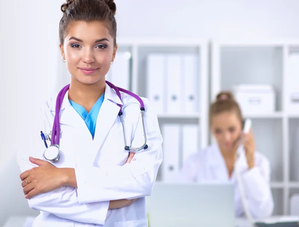 Portrait of young woman doctor with white coat standing in hospital — Stock Photo, Image