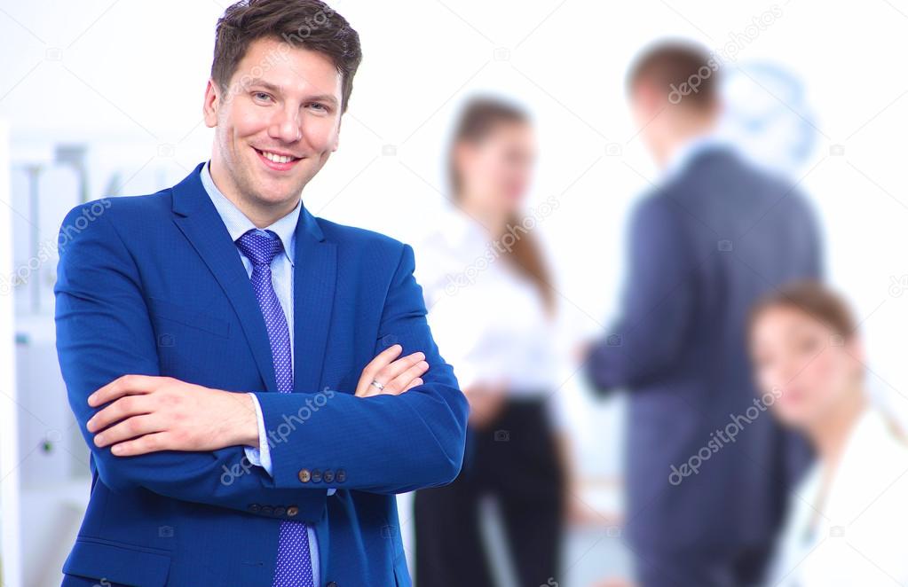 Successful business man standing with his staff in office