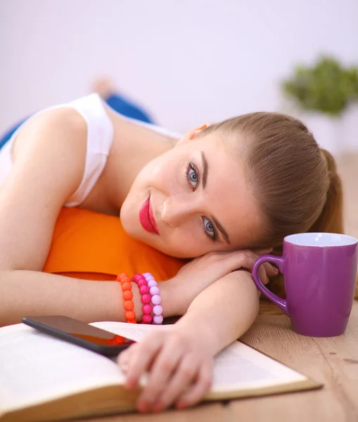 Smiling young woman lying on a white floor with pillow — Stock Photo, Image