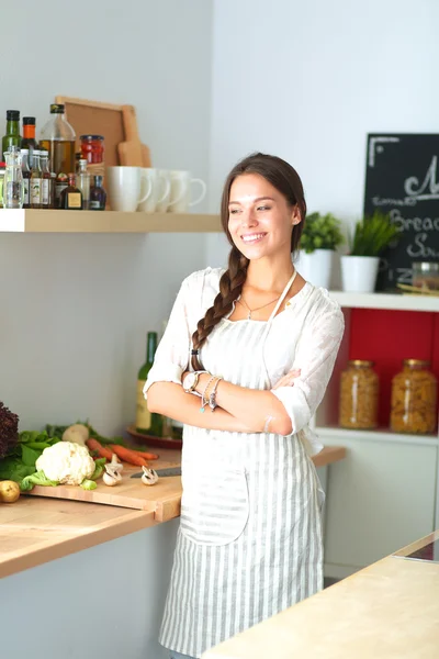 Mladá žena stojící u stolu v kuchyni — Stock fotografie