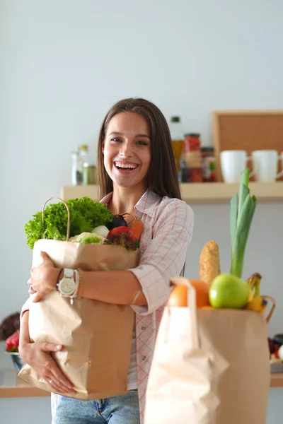 Jeune femme tenant sac d'épicerie avec des légumes — Photo