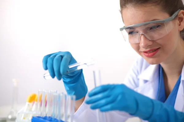 Woman researcher is surrounded by medical vials and flasks, isolated on white background Stock Image