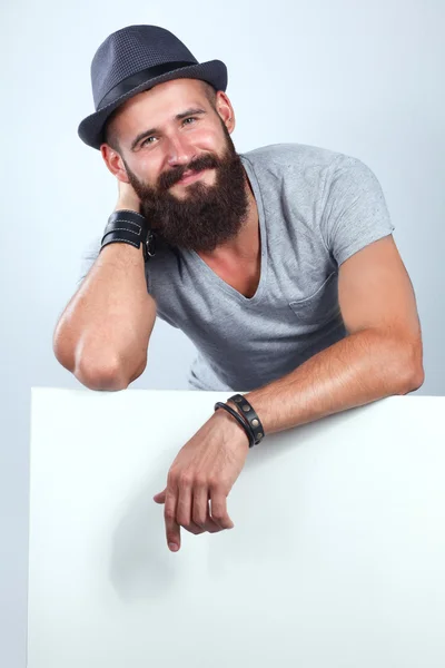 Portrait of young man in hat standing near blank, isolated on white background — Stock Photo, Image