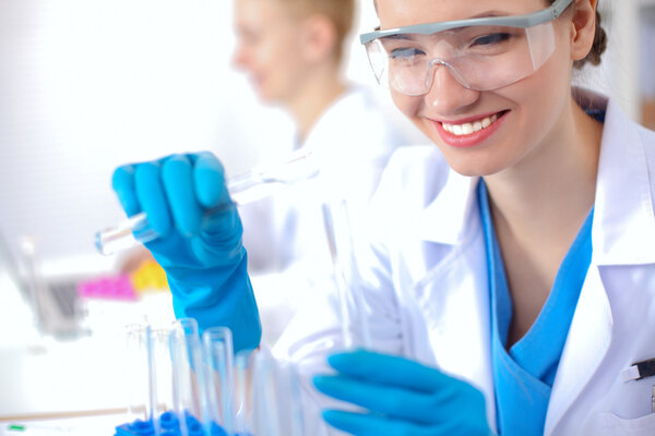 Woman researcher is surrounded by medical vials and flasks, isolated on white background