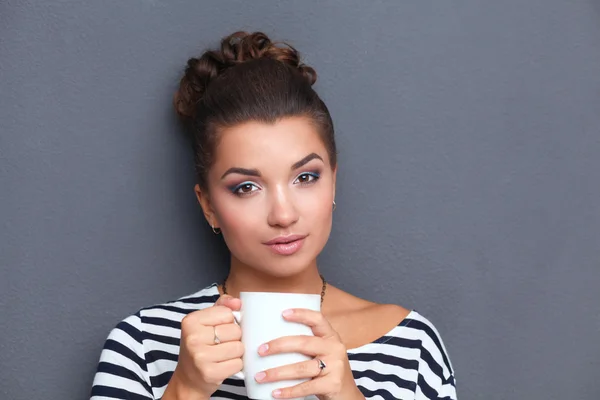 カップの紅茶やコーヒーを持つ若い女性の肖像画 — ストック写真