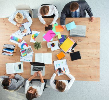 İş adamları iş toplantısında, ofiste oturup tartışıyorlar.