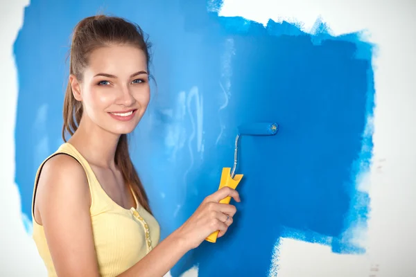 Feliz bela jovem fazendo pintura de parede — Fotografia de Stock