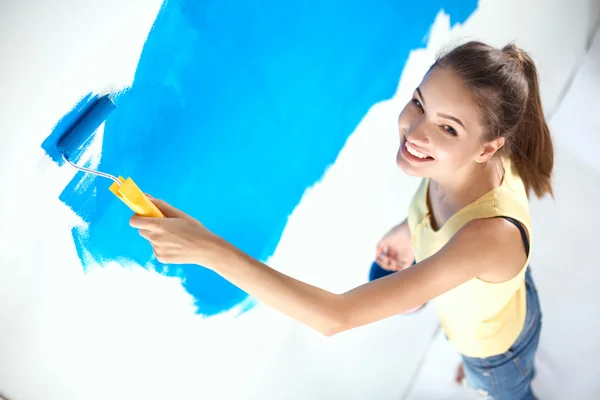 Szczęśliwa piękna młoda kobieta maluje ściany — Zdjęcie stockowe