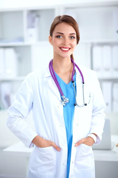 Retrato de una joven doctora con una bata blanca de pie en el hospital —  Fotos de Stock