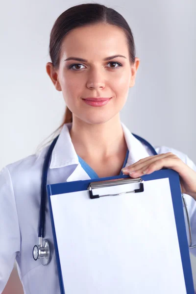 Médico sonriente con una carpeta en uniforme de pie en el hospital — Foto de Stock