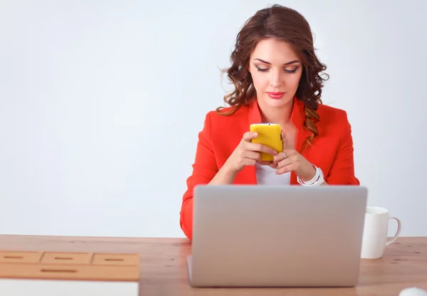 Mujer atractiva sentada en el escritorio en la oficina, trabajando con el ordenador portátil — Foto de Stock