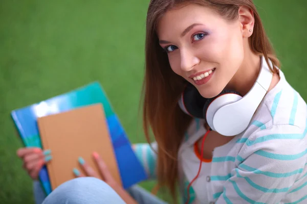 Jonge vrouw met laptop zittend op groen gras — Stockfoto