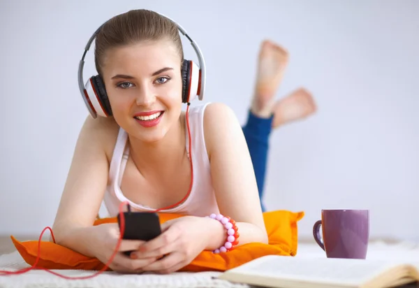 Giovane donna sdraiata sul pavimento e ascoltare musica — Foto Stock