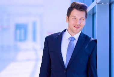 Ofisteki pencerenin yanında duran işadamının portresi