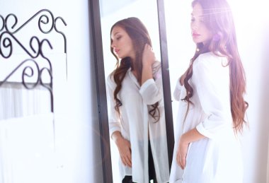 Genç kadın kendini evde aynada yansıma arıyor